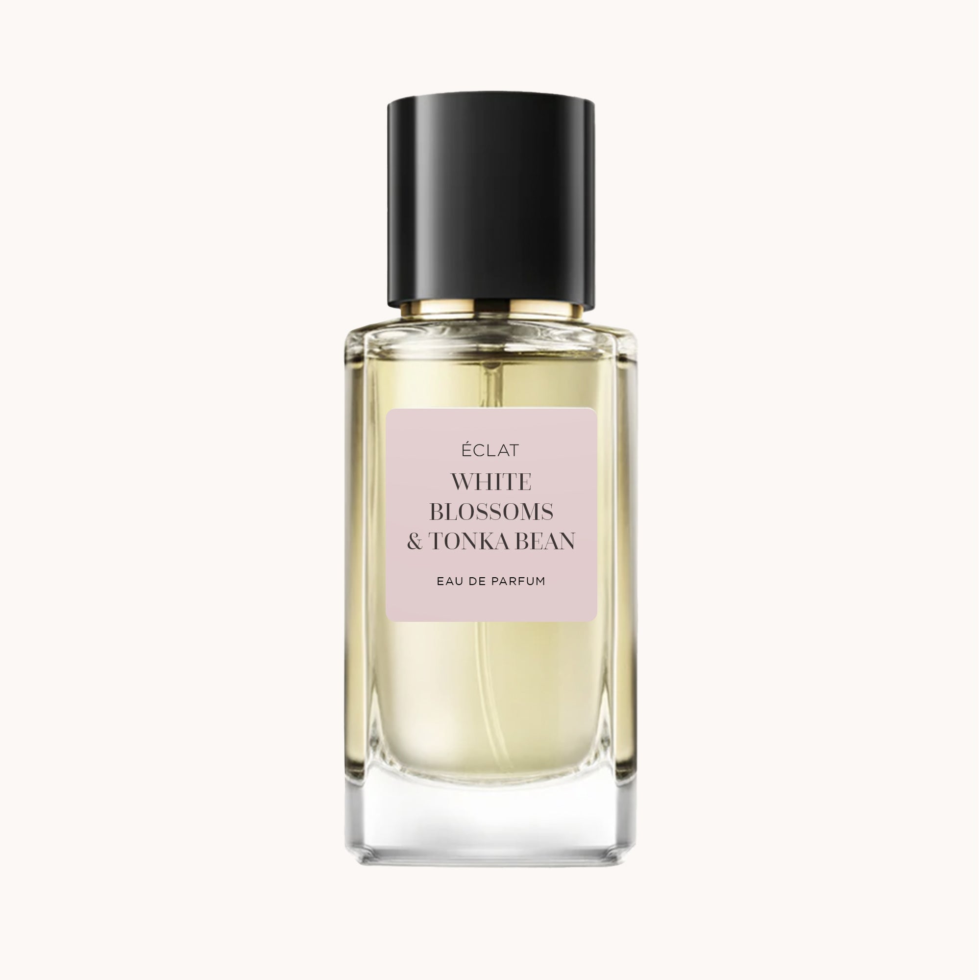 ÉCLAT White Blossoms & Tonka Bean in einem facettierten Glasflakon mit schwarzer Kappe und einem sanften rosa Etikett.