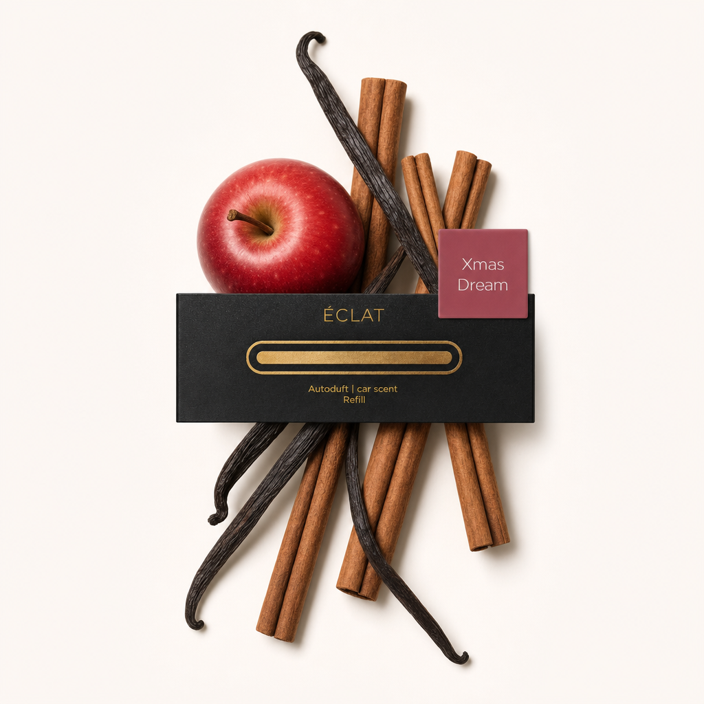 Ein Arrangement aus duftenden Zimtstangen, Vanilleschoten und einem roten Apfel, umgeben von der originalen schwarzen ÉCLAT-Verschlusskappe mit Etikett.